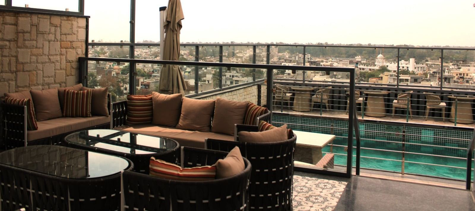 A rooftop lounge with a spacious patio and an adjacent swimming pool at BluSalzz Residence, Amritsar